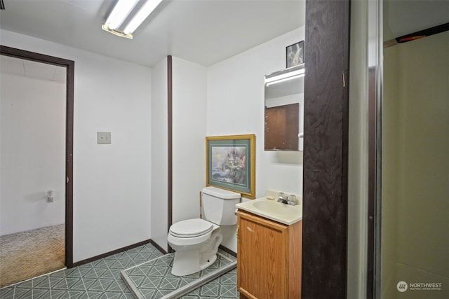 bathroom with tile patterned flooring, vanity, and toilet