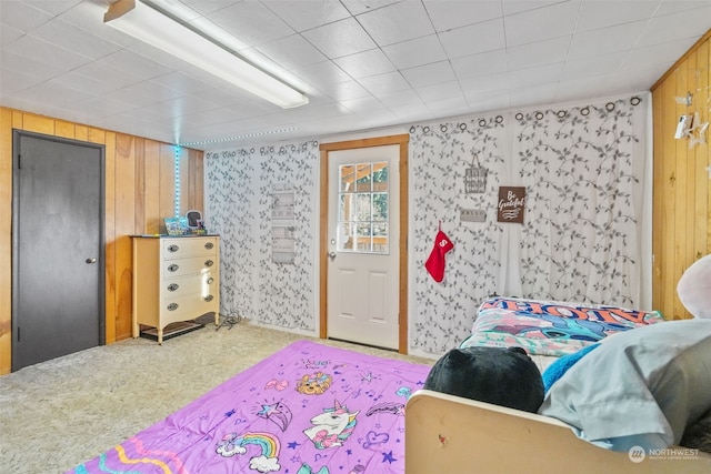 bedroom featuring carpet and wood walls