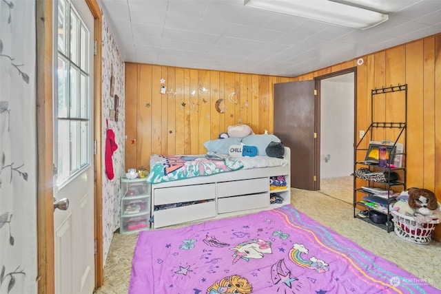 bedroom featuring carpet flooring and wooden walls