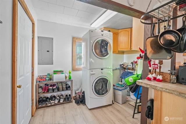 washroom with stacked washer / drying machine, light hardwood / wood-style floors, and electric panel