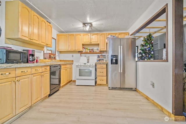 kitchen featuring light brown cabinets, light hardwood / wood-style flooring, and black appliances