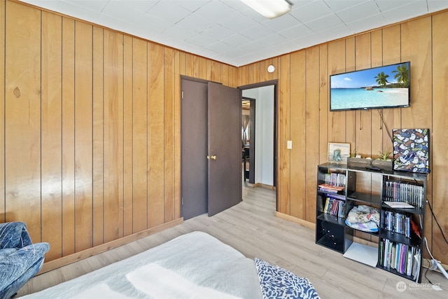 bedroom featuring wood walls and light wood-type flooring