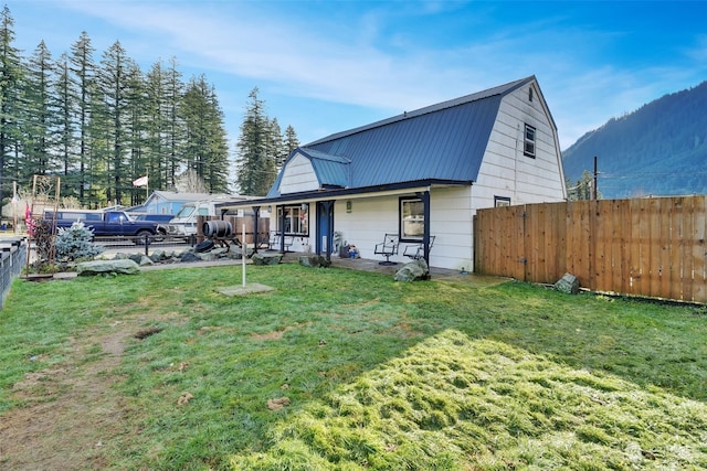 view of front facade featuring a mountain view, covered porch, and a front yard