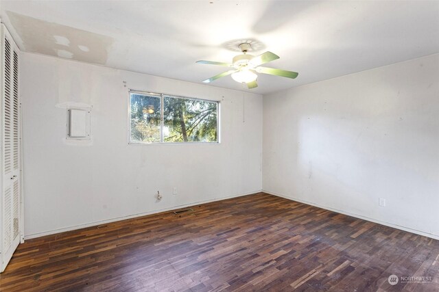 spare room featuring ceiling fan and dark wood-type flooring