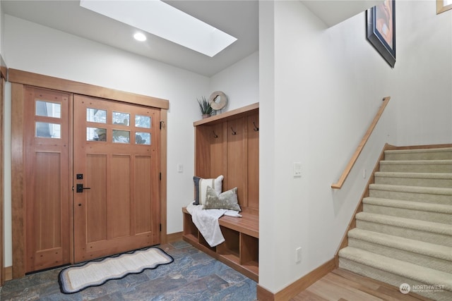 mudroom with a skylight and wood-type flooring