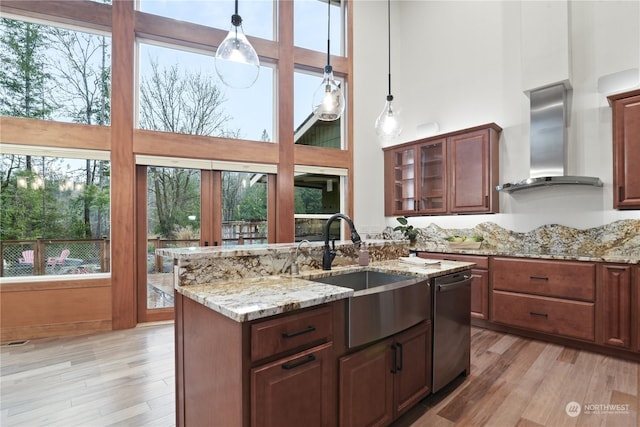 kitchen with wall chimney exhaust hood, dishwasher, sink, and a high ceiling