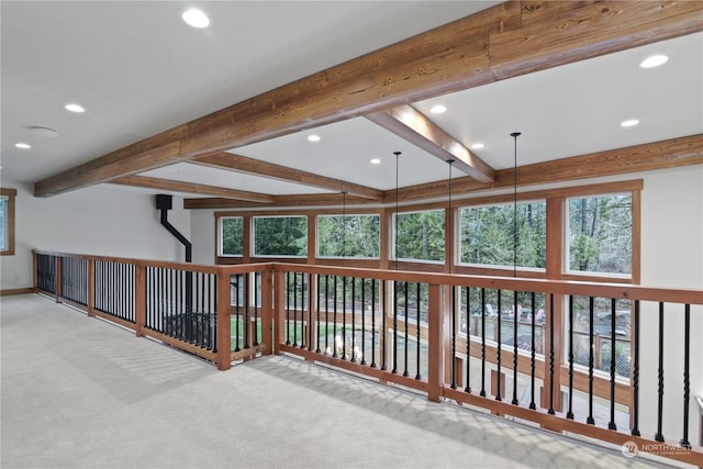 hallway featuring beamed ceiling and light colored carpet