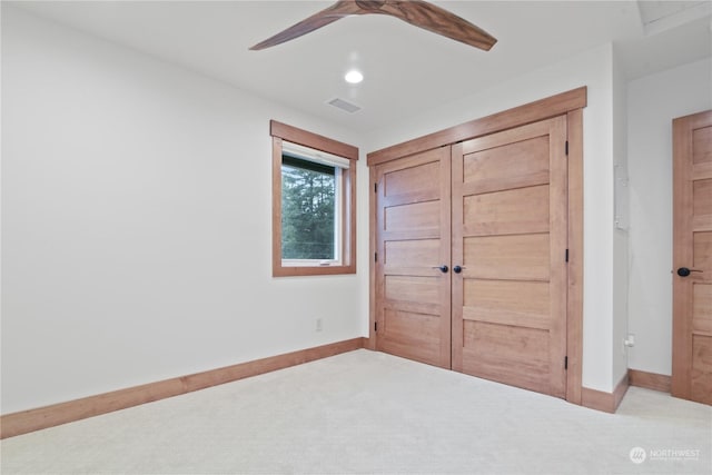 unfurnished bedroom with light carpet, a closet, and ceiling fan