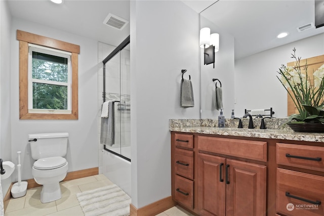 full bathroom featuring toilet, tile patterned floors, vanity, and bath / shower combo with glass door