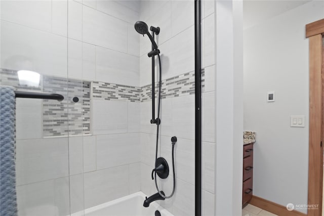 bathroom featuring tiled shower / bath combo and vanity