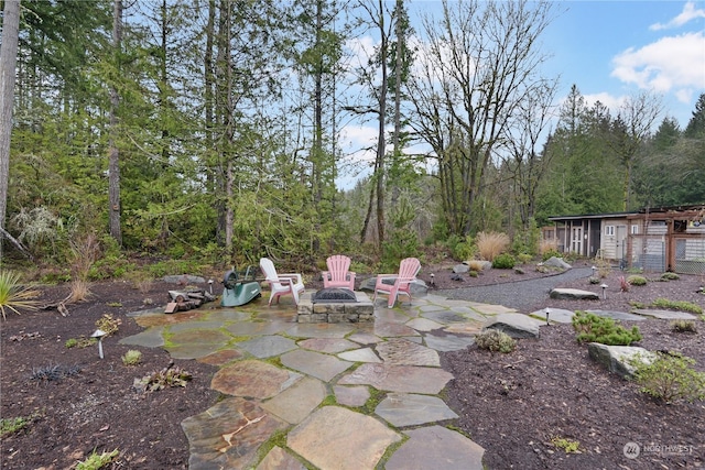 view of patio / terrace featuring a fire pit and an outdoor structure