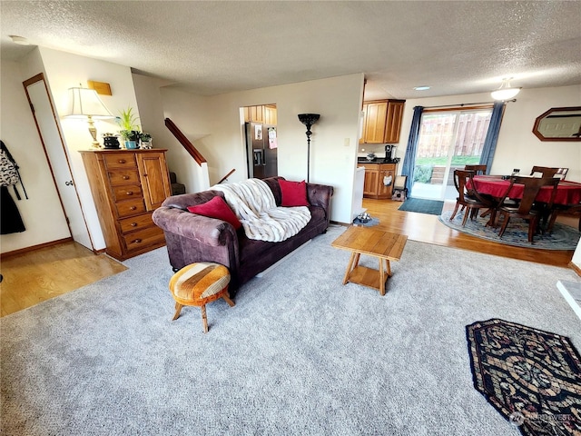 living room featuring light hardwood / wood-style flooring and a textured ceiling