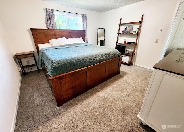 bedroom with a textured ceiling and light colored carpet