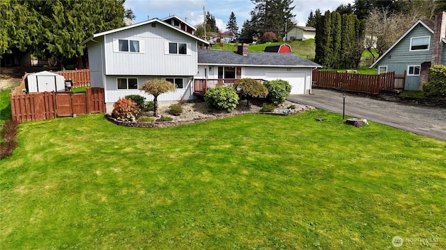117 Heritage Dr, Elma, WA 98541 - tri-level home with a front yard, an attached garage, fence, and aphalt driveway