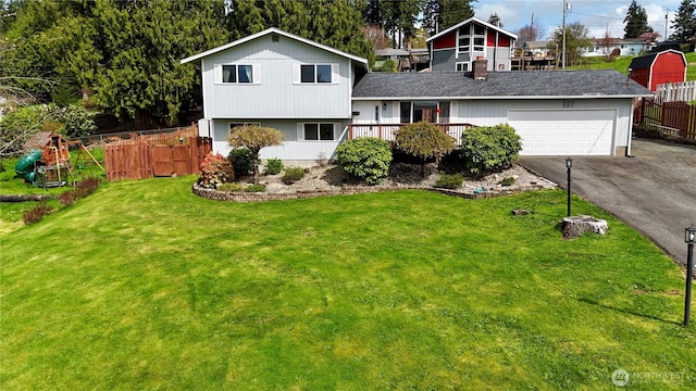 117 Heritage Dr, Elma, WA 98541 - split level home featuring a garage, roof with shingles, a front yard, fence, and driveway