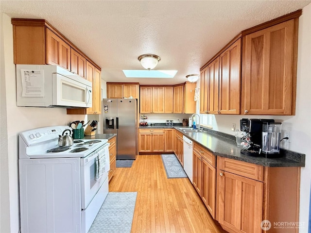 117 Heritage Dr, Elma, WA 98541 - kitchen with white appliances, a textured ceiling, a sink, dark countertops, and light wood finished floors