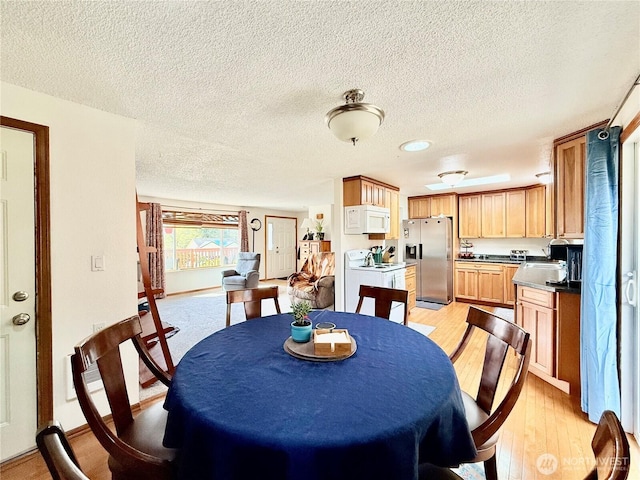 117 Heritage Dr, Elma, WA 98541 - dining area with light wood-style floors, baseboards, and a textured ceiling