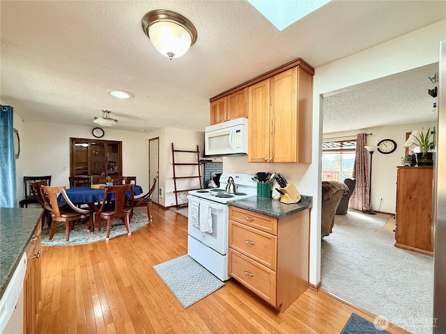 117 Heritage Dr, Elma, WA 98541 - kitchen with light wood-style flooring, dark countertops, white appliances, and a textured ceiling