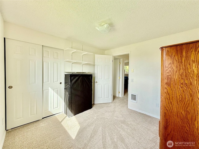 117 Heritage Dr, Elma, WA 98541 - unfurnished bedroom with light carpet, baseboards, visible vents, and a textured ceiling