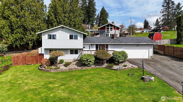 117 Heritage Dr, Elma, WA 98541 - split level home featuring driveway, an attached garage, a front lawn, fence, and a shingled roof