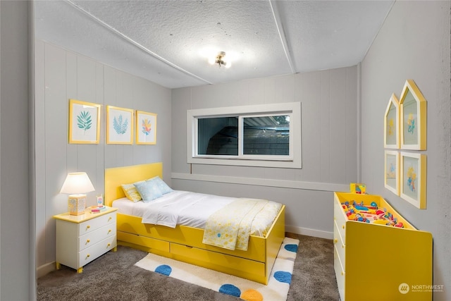 bedroom featuring dark carpet and a textured ceiling