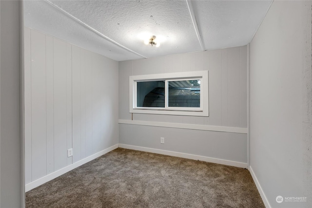 carpeted spare room featuring a textured ceiling