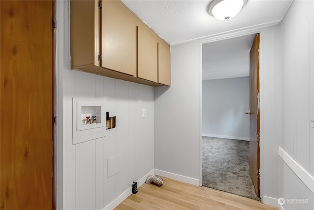 washroom with light hardwood / wood-style flooring, cabinets, and washer hookup