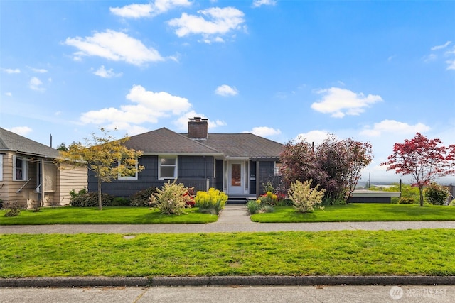 ranch-style house with a chimney and a front yard