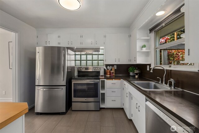 kitchen with stainless steel appliances, open shelves, a wealth of natural light, and a sink