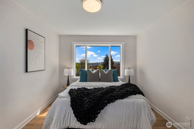 bedroom with light wood-type flooring and baseboards