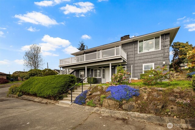 traditional-style home featuring stairs, a chimney, and a deck