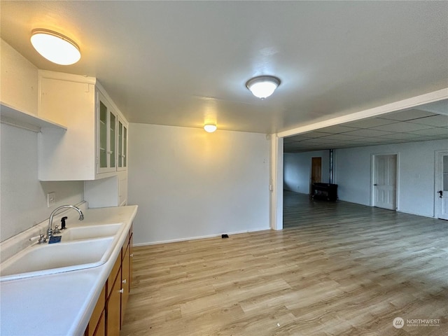 kitchen featuring light hardwood / wood-style floors, white cabinetry, and sink