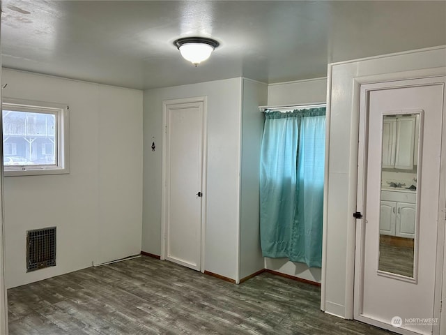 unfurnished bedroom with dark hardwood / wood-style flooring