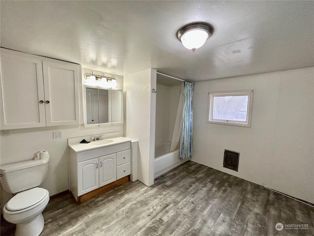 full bathroom featuring hardwood / wood-style floors, vanity, shower / bath combination with curtain, and toilet