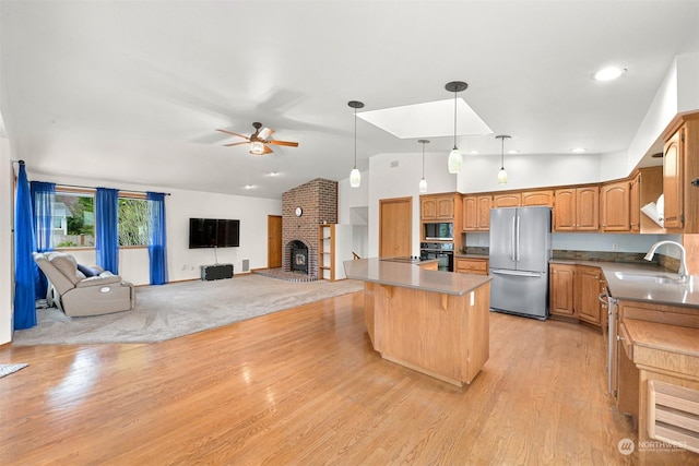 kitchen with sink, light hardwood / wood-style floors, lofted ceiling, and appliances with stainless steel finishes