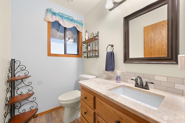 bathroom featuring decorative backsplash, toilet, vanity, and hardwood / wood-style flooring