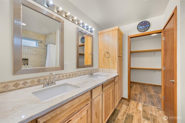 bathroom featuring hardwood / wood-style flooring, vanity, and walk in shower