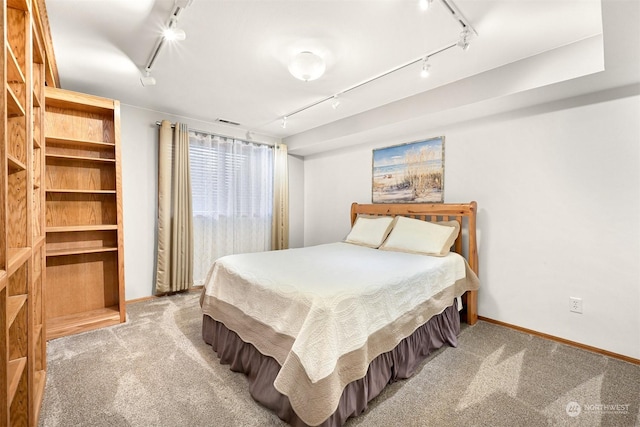 bedroom with light carpet and track lighting