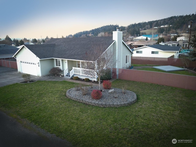 ranch-style home with a lawn, a garage, and covered porch