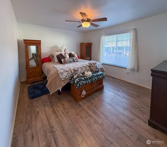 bedroom with ceiling fan and wood-type flooring