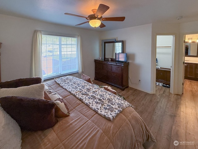 bedroom featuring ensuite bath, a ceiling fan, and wood finished floors