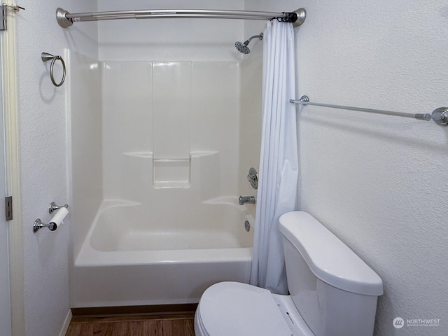 bathroom with shower / tub combination, wood finished floors, and toilet