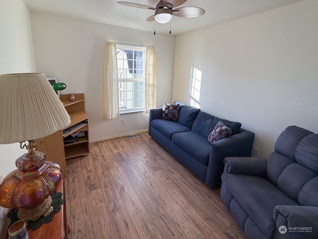 living room featuring ceiling fan and hardwood / wood-style flooring