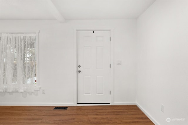 unfurnished room featuring beamed ceiling and wood-type flooring