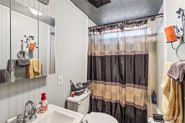 full bathroom with toilet, shower / bathtub combination with curtain, sink, and wooden walls