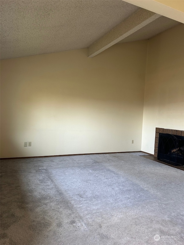 unfurnished living room with carpet flooring, a textured ceiling, and lofted ceiling with beams