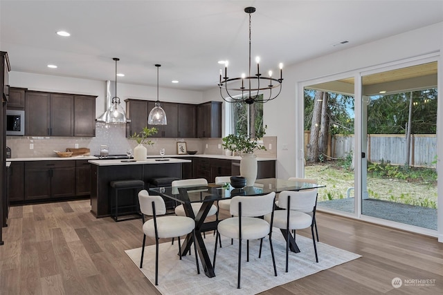 dining area featuring light hardwood / wood-style floors and an inviting chandelier