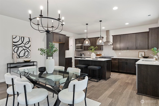 dining space with an inviting chandelier, light hardwood / wood-style flooring, and sink