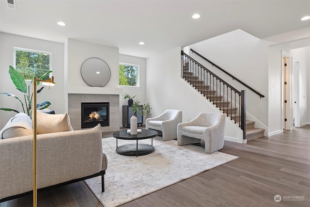 living room with hardwood / wood-style flooring, a healthy amount of sunlight, and a fireplace