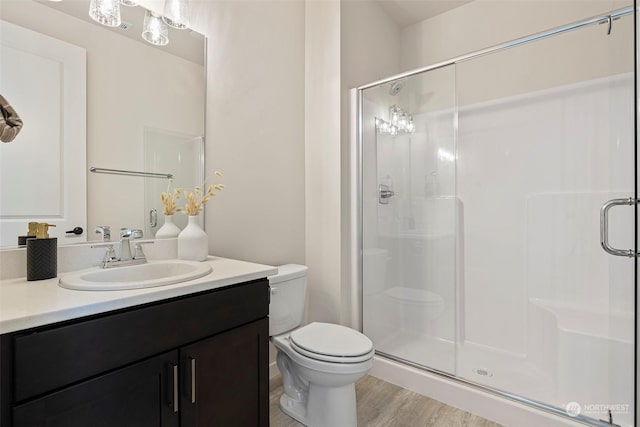 bathroom with vanity, hardwood / wood-style flooring, toilet, and walk in shower